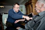 Huslæge. Læge Tue Christoffersen (tv) måler blodtrykket på sin patient John Lindberg. Det foregår hjemme i Lindbergs stue. »Jeg ringer direkte til Tue, hvis jeg har det dårligt«, fortæller den 90-årige herre, som betaler 1.800 kroner for besøget. Foto: Joachim Adrian 