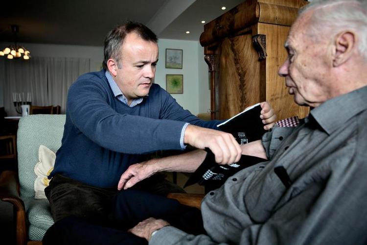 Huslæge. Læge Tue Christoffersen (tv) måler blodtrykket på sin patient John Lindberg. Det foregår hjemme i Lindbergs stue. »Jeg ringer direkte til Tue, hvis jeg har det dårligt«, fortæller den 90-årige herre, som betaler 1.800 kroner for besøget. Foto: Joachim Adrian 
