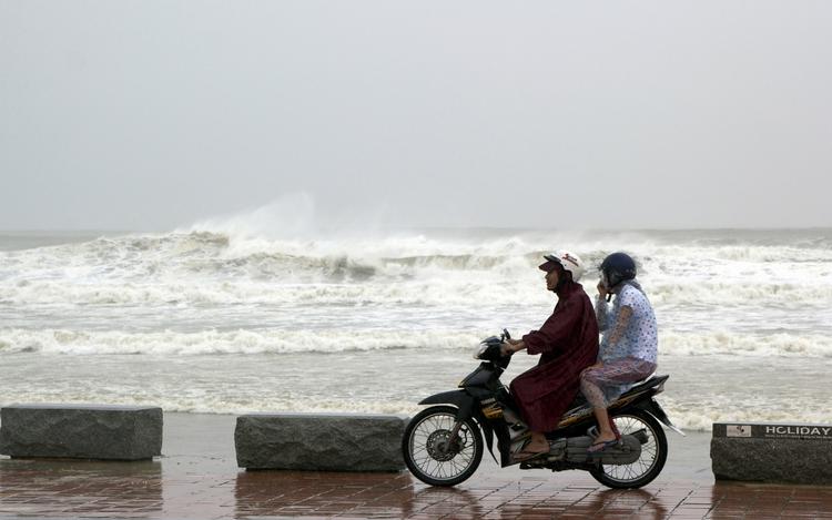 Ventetid. Et vietnamesisk par kører en tur i havnebyen Danang mens man venter på supertyfonen Yolanda. 