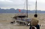 Tyfon. En mand betragter en synkende turistbåd i Ha Long Bay i Vietnam, hvor tyfonen, der har dræbte mange i Filippinerne i morges gik i land. 