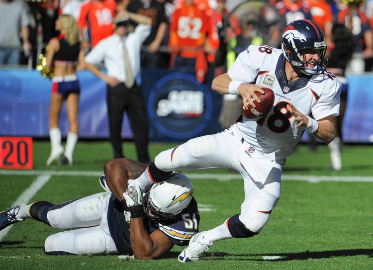 Av. Peyton Manning (th) leverede varen mod San Diego-spillerne, der gik hårdt til superstjernen. 
