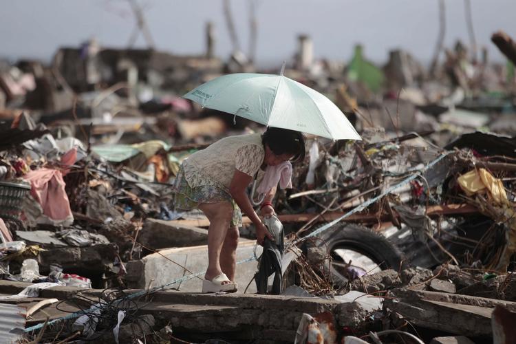 HJEMLØS. En kvinde leder efter sine ejendele i det, der engang var hendes hjem i Tacloban efter tyfonen. 