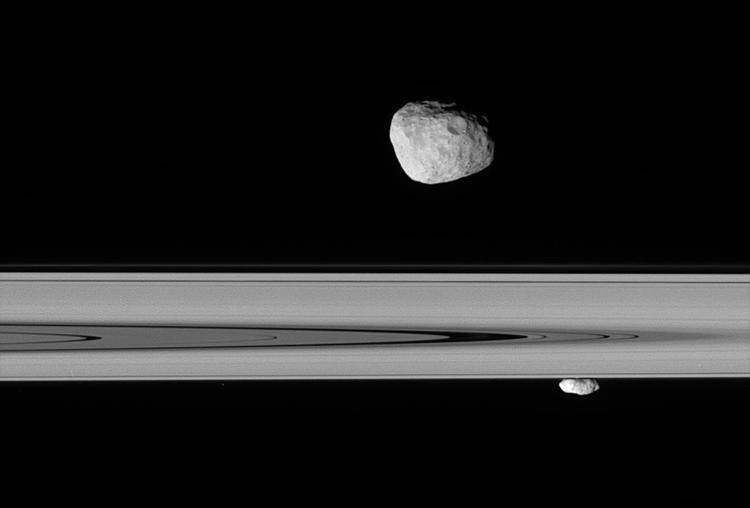 Månerne Janus og Prometheus ses her svævende langs Saturns ringe. 