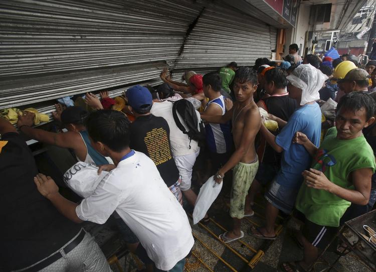 Kaostilstande. Med kun 34 betjente fra den østlige og hårdt ramte Visayas-region, der mødte op på arbejde efter fredagens tyfon, beretter den Filippinske avis The Philippine Star og tusindvis af sultne mennesker, der plyndrer butikker for at få mad. På billedet stormes en lille fødevarebutik i byen Tacloban. 