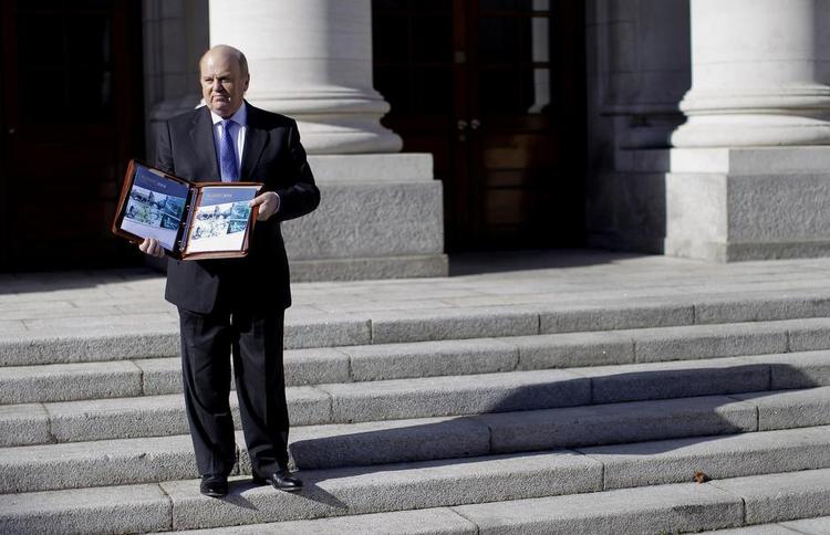 Eftergivende. Den irske finansminister - her med næste års finanslov - vil godt lukke skattehuller - dog kun lidt efter lidt. Foto: Peter Morrison 