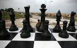 vm-opgør. En indisk dreng leger med et kæmpemæssigt skak-bræt ved kysten i Chennai, hvor VM-matchen mellem  Viswanathan Anand og Magnus Carlsen foregår. 