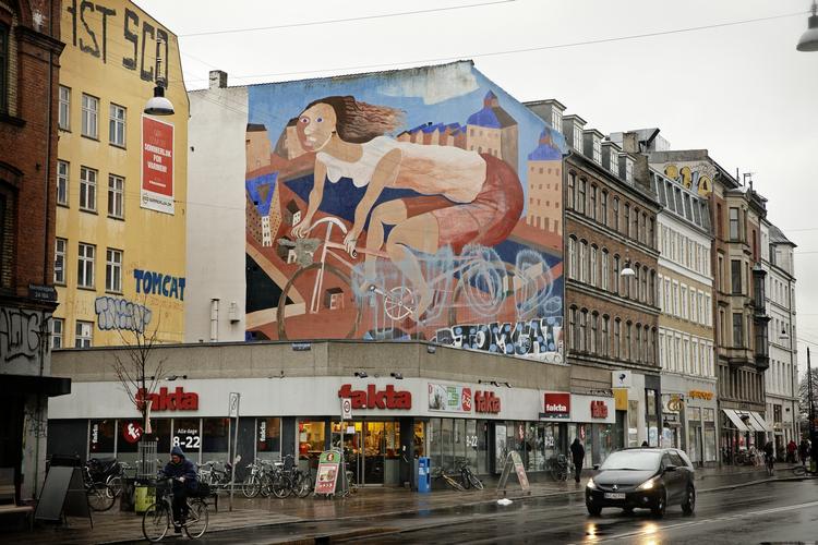 Sprøjtet. Cykelpigen, der er malet på husgavlen ind mod Ravnsborggade på Nørrebro, er blevet sprøjtet til med lyseblå maling. 