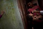 POLIOBEKÆMPELSE. Mens familiens mindste får sin vaccine sætter en sundhedsarbejder et mærke på huset for at vise, at poliobekæmpelseskampagnens mandskab har besøgt hjemmet. 