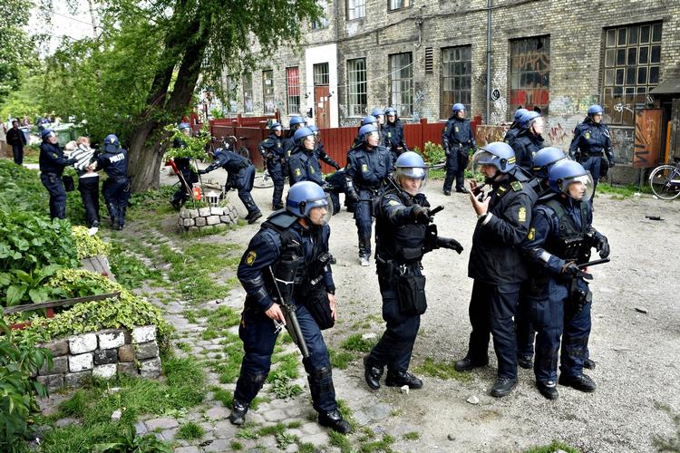 URO. Politiets indsats mod Christianias hashhandel har ofte udløst ballade som her, hvor betjente i kampdragter eskorterer en anholdt ud fra fristaden. 