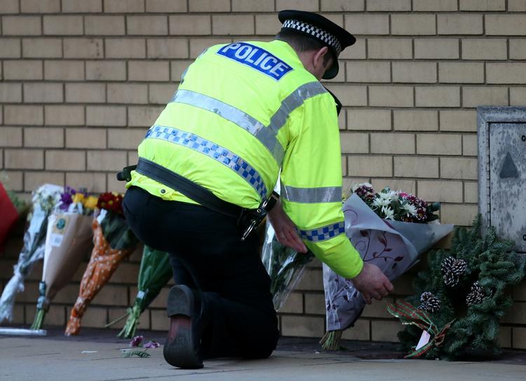 Mindes. Folk lægger blomster ved ulykkesstedet i Glasgow. 