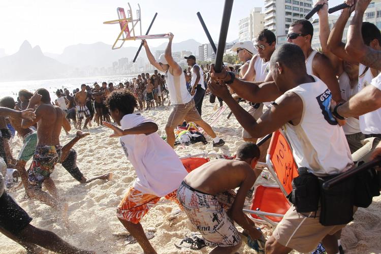 Optøjer. Kriminelle, som deltager i røverier på stranden Arpoador i Rio er fanget af kameralinsen mens de støvsuger stranden for værdier. 
