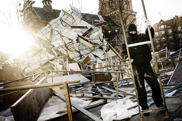 Et håndværker ved Nikolaj Plads i det indre København forsøger at genopbygge et væltet stillads. 