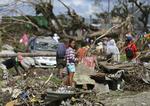 Tyfonefterveer. En overlevende står i ruiner i Tacloban i Filippinerne præcist en måned efter at tyfonen Haiyan ramte. 