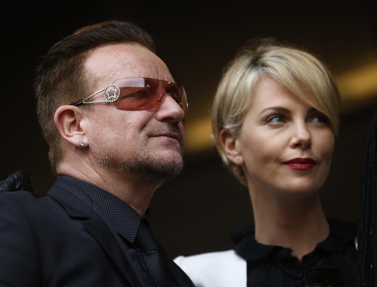 Mindehøjtidelighed. Forsanger og lobbyist Bono sammen med den sydafrikanske skuespiller Charlize Theron til Nelson Mandelas mindeceremoni. 
