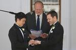 Ægtefolk. Ceremonimester Rodger Munson (midten) ser til mens Chris Teoh (tv.) sætter vielsesringen på Ivan Hinton's finger  foran Old Parliament House i den australske hovedstad  Canberra. 