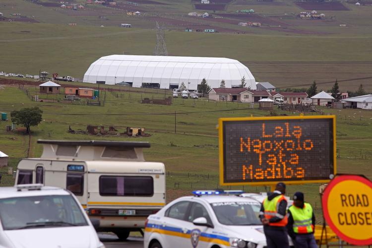 BLOKADE. I landsbyen Qunu stopper politiet biler på hovedvejen, der går forbi Mandela hus, mens en kuppel, der skal bruges under Mandelas begravelse på søndag, bliver opført. 