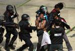 PROTEST. En regeringsfjendtlig demonstrant bliver tilbageholdt af politiet under en demonstration ved et stadium i Bangkok i dag, hvor omkring 30 partier var mødt op for at lade sig registrere til det planlagte parlamentsvalg i Thailand 2. februar 2014. Demonstranterne forlanger, at valget udskydes. 