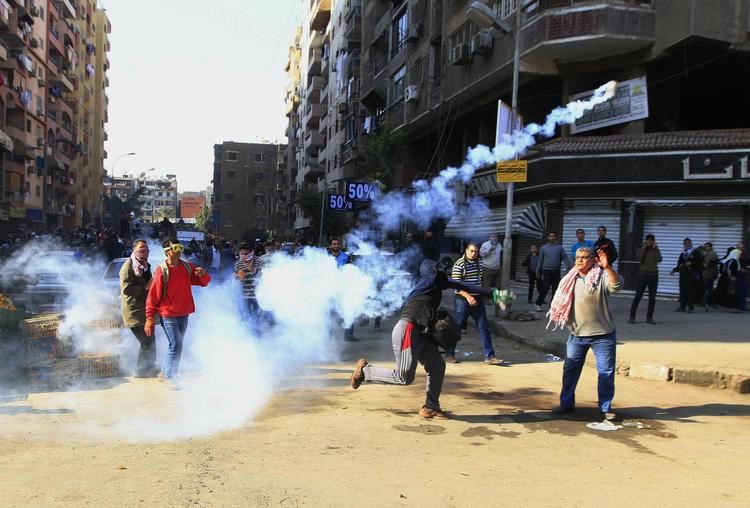 En demonstrant kaster en tåregasgranat mod de egyptiske sikkerhedsstyrker i Kairo. 