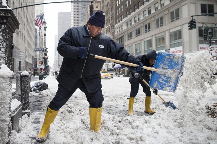Vintertjans. Gadefejere skovler sne på  Fifth Avenue, efter at en større snestorm ramte New York. 