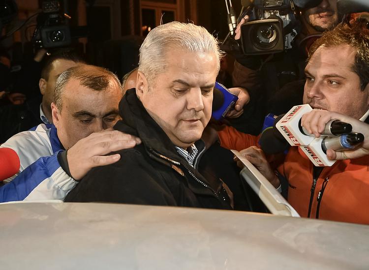 Dømt. Politibetjente fører Adrian Nastase ind i en bil ved retten i Bukarest. 