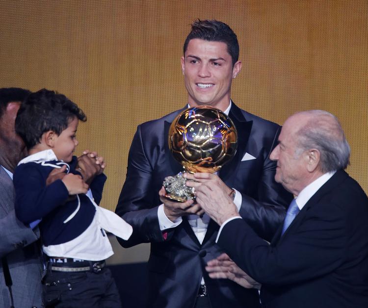 Guldbold. Christiano Ronaldo modtager  Ballon d'Or 2013 flankeret af FIFA-præsident Joseph Blatter (t.v.) and Ronaldos søn Ronaldo Junior (t.h.). 