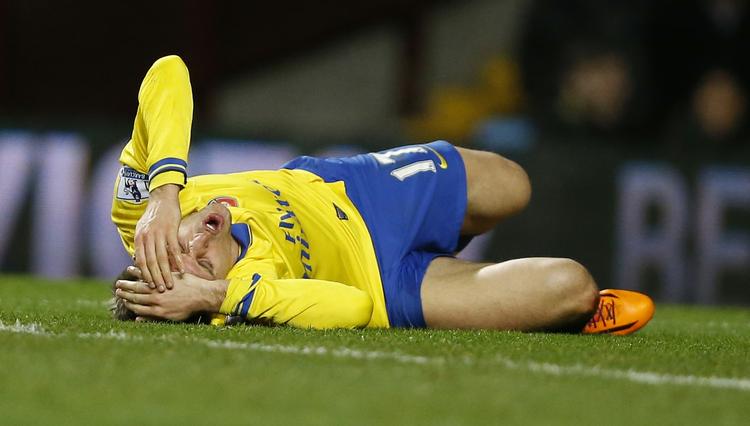 skadesramt. Arsenals Nacho Monreal er røget i græsset efter et sammenstød, der kan have kostet en skade i foden i kampen mod Aston Villa. 