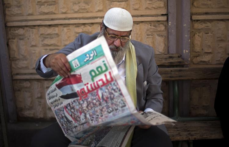 Valg. Egypter læser en avis i dag med overskriften 'Ja til forfatningen' i dag. 