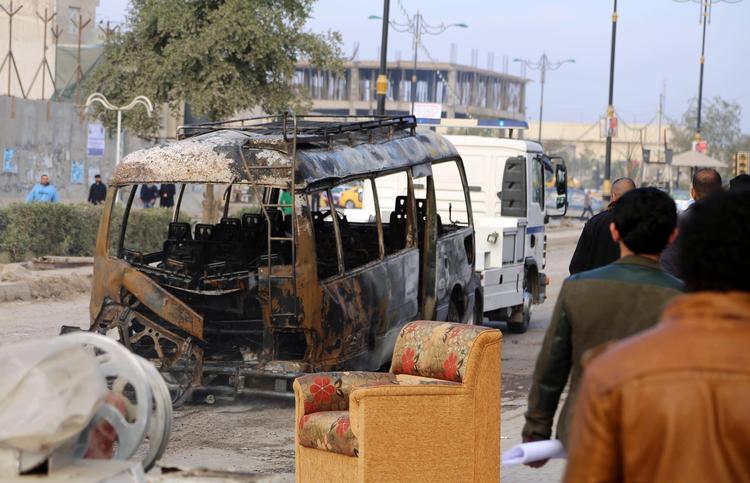 Bombet. Indbyggere inspicerede i går en udbombet bus i Iraks hovedstad, Bagdad. I dag er mindst 52 mennesker blevet dræbt af bomber i Irak. 
