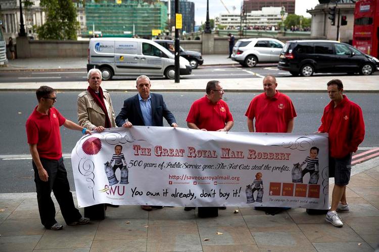Postrøveri. Britiske postarbejdere viser deres vrede over efterårets privatisering af deres arbejdsplads. Plakaten taler om »det store røveri af Royal Mail«. 