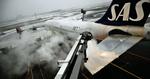 Klar. En SAS-flyver renses for sne og is, inden den flyver af sted mod USA. Når flyet først er i luften, skulle der ikke være risiko for nye isdannelser på vingerne. 