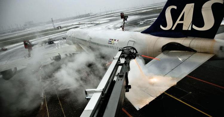 Klar. En SAS-flyver renses for sne og is, inden den flyver af sted mod USA. Når flyet først er i luften, skulle der ikke være risiko for nye isdannelser på vingerne. 
