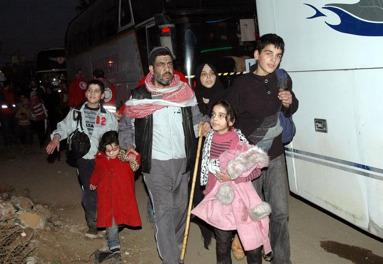 Syrien. Flere indbyggere er i dag blevet evakueret fra den belejrede by Homs. I søndag blev flere flygtninge som her reddet ud af byen. 
