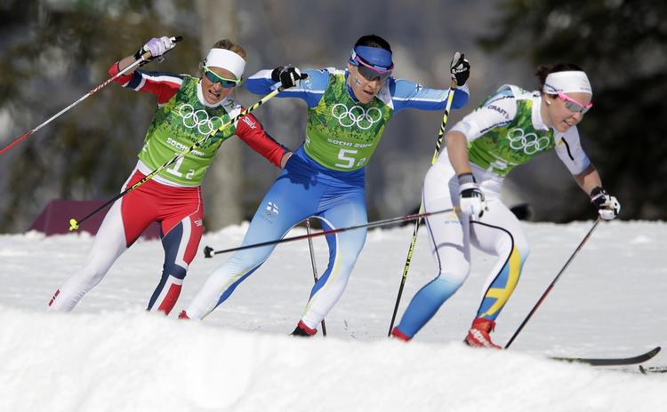 Guldkamp. Norges Therese Johaug, Finlands Aino-Kaisa Saarinen, and Sveriges Emma Wiken, i en kurve under kvinderns langrends-stafet. 