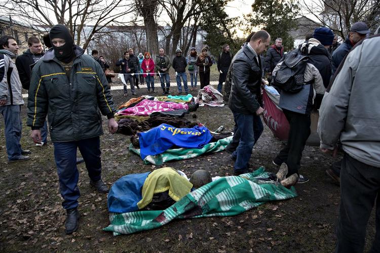 Drab. Mindst 70 mennesker menes at være blevet dræbt i Ukraine i går, og flere hoteller i Kijevs centrum havde ifølge udenlandske journalister døde og sårede liggende i lobbyen. I haven bag Skt. Michaels Kirke nogle hundrede meter fra Uafhængighedspladsen bliver døde samlet og registreret.  - Foto: 