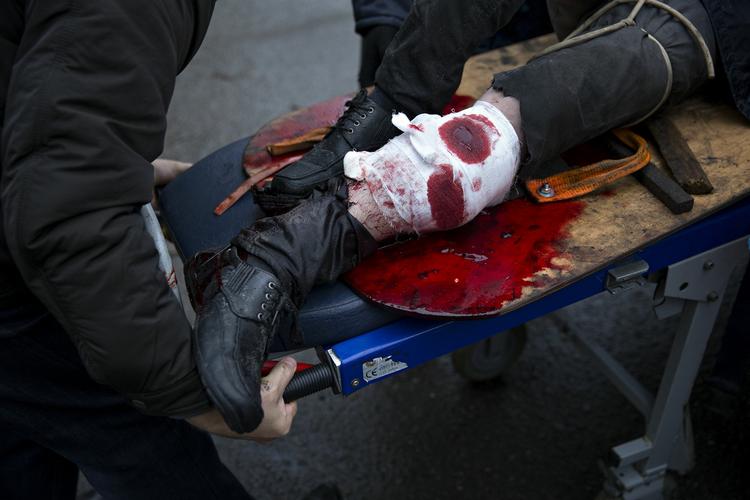 En såret demonstrant bliver skudt i benet og slæbes væk fra pladsen til en sidegade, hvor ambulancer kommer til, og hvor læger gør, hvad de kan på stedet. 