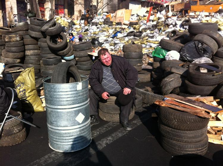 Uroligheder. En ukrainer tager sig en slapper ved barrikaderne på Europa-pladsen, hvor der tidligere har været kampe. 