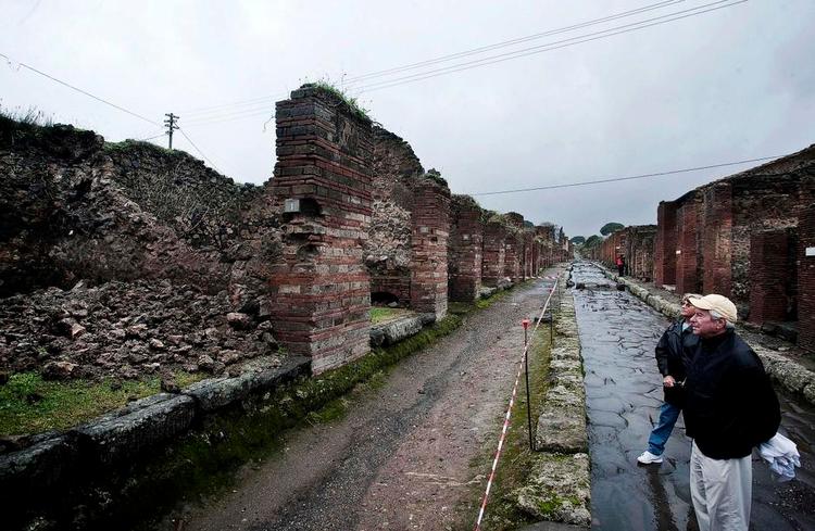 UDSAT. En turist foran et murkollaps i Pompeji efter et heftigt skybrud i november 2010. Ruiner og koralrev er ligesom en del anden verdensarv truet af det nye klima. 