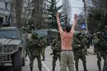 Konflikt. En ukrainsk mand har smidt overtøjet i protest mod de russiske soldater, som har taget kontrollen med store dele af Krim-halvøen. Her ses de i Balaklava i udkanten af havnebyen Sevastopol. der i forvejen er hjemsted for en stor russisk flådestyrke. 