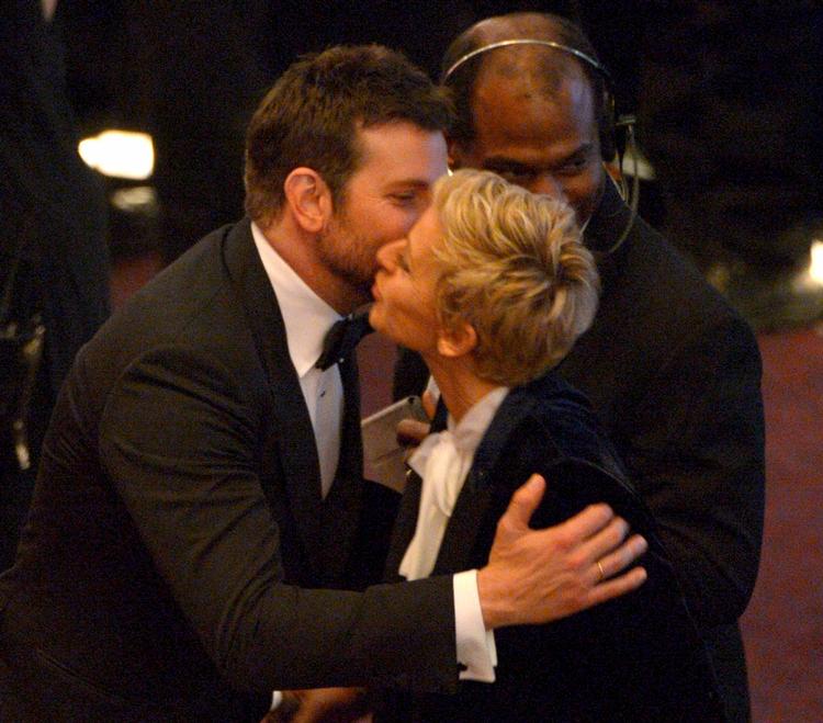 Værten sniger til sig til et kys med Bradley Cooper. Eller er det omvendt? 