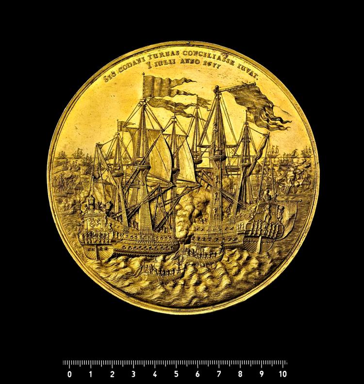 Gemt. En af Nationalmuseets fornemmeste guldmedaljer viser søslaget ved Køge Bugt i 1677, hvor danske og svenske orlogsskibe kæmpede mod hinanden. 