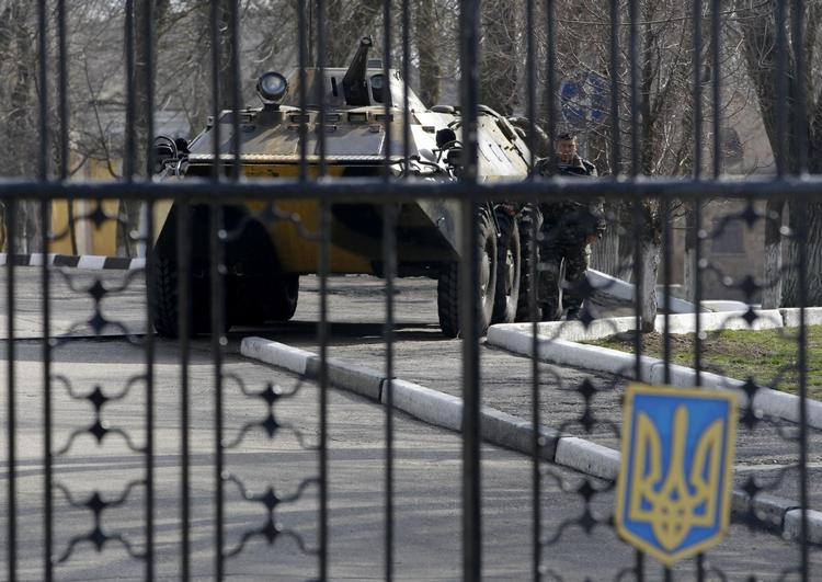 uro. Et ukrainsk, bevæbnet køretøj indespærret bag gitteret på militærbase på Krim. Russiske styrker holder de ukrainske soldater og kampvogne i skak og forhindrer dem i at forlade basen medmindre de overgiver sig. 