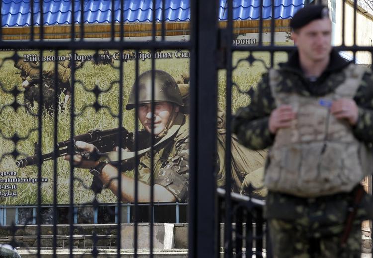 uro. En ukrainsk soldat holder vagt ved porten på en militærbase i Kerch, Ukraine. 