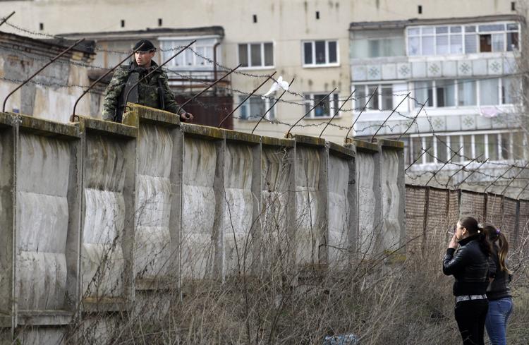 Konflikt. En ukrainsk soldat står vagtog taler med lokale ved en kaserne i Perevalne på halvøen Krim, der hører under Ukraine. 