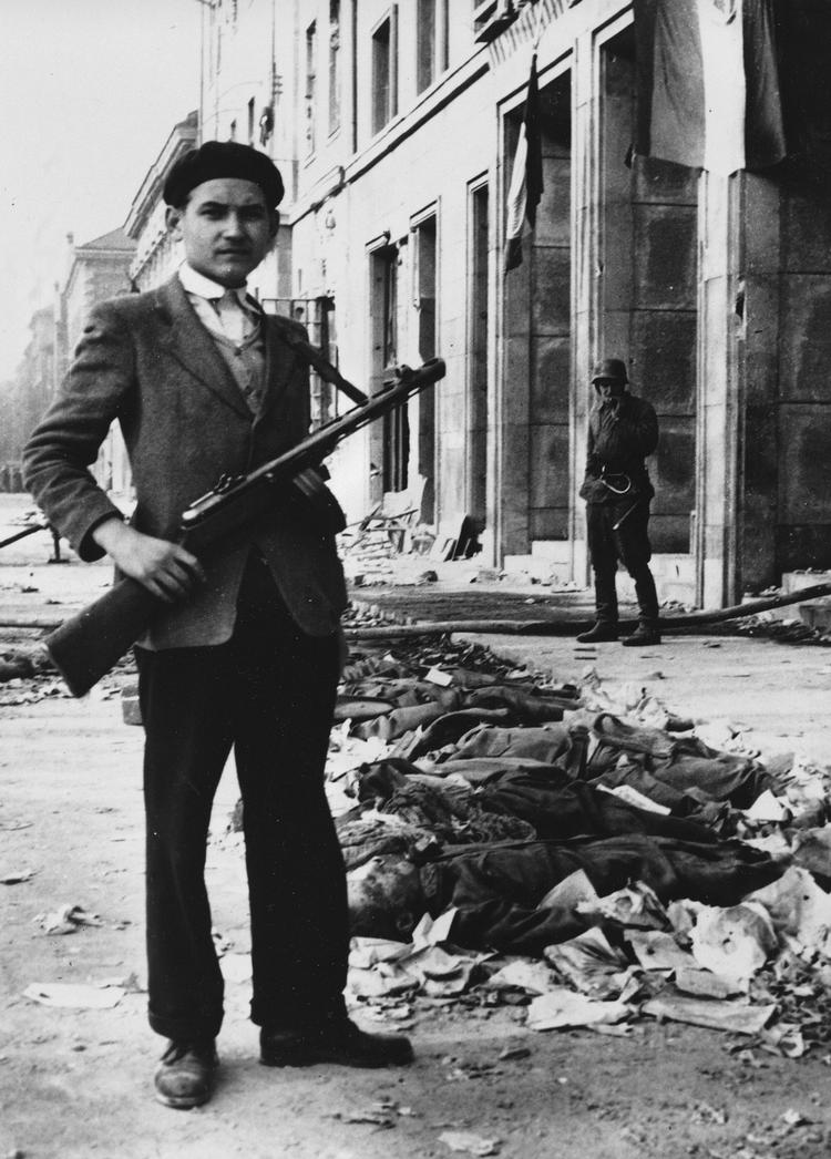 En ungarnsk militssoldat står med en lang række af døde sovjetiske soldater 4. november 1956. Det anslås at flere end 7.000 sovjetiske soldater og mellem 25.000 og 50.000 ungarere blev dræbt under opstanden. 