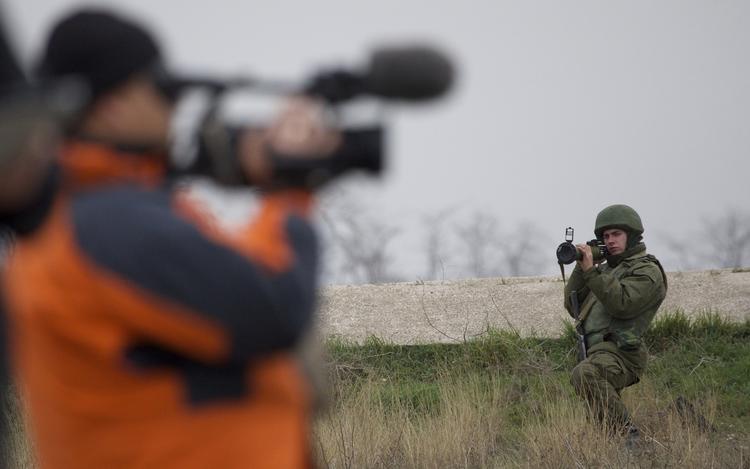 KONFLIKT. Russisk soldat truer civil kameramand med et raketstyr ud for en ukrainsk luftbase i Belbek på Krim. 