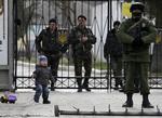 Internationalt. Et lille barn leger midt blandt ukrainske og russiske tropper ved en militærbase i Ukraine. 
