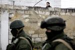 Krim. Flere andre militære baser på Krim er blevet besat af russiske soldater. Her er det en base i byen Simferopol, hvor en ukrainsk soldat kigger ud og ned på de russiske. 