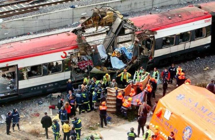 ANGREB. Redningsarbejdere ved et af de bomberamte tog i Madrid for ti år siden. Terrorbombernes ofre er blevet mindet i dag i Spanien. 