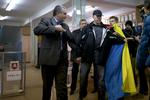 AFSTEMNING. Mand med det ukrainske flag holdes tilbage ved et valgsted, mens lederen af den lokale regering på halvøen, Sergej Aksyonov, besøger stemmested. 