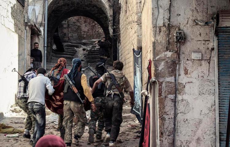 Syriensfarere. Syriske oprørere slæber her en såret kampfælle bort. Mindst 90 danske muslimer er taget til Syrien for at kæmpe, men enkelte har droppet rejseplanerne efter exit-samtaler med PET. 